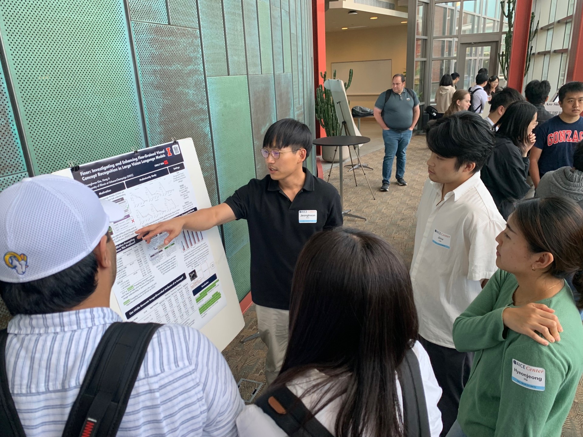 A man points to a poster explaining a research project at the 2024  AICE Fall Research Symposium.